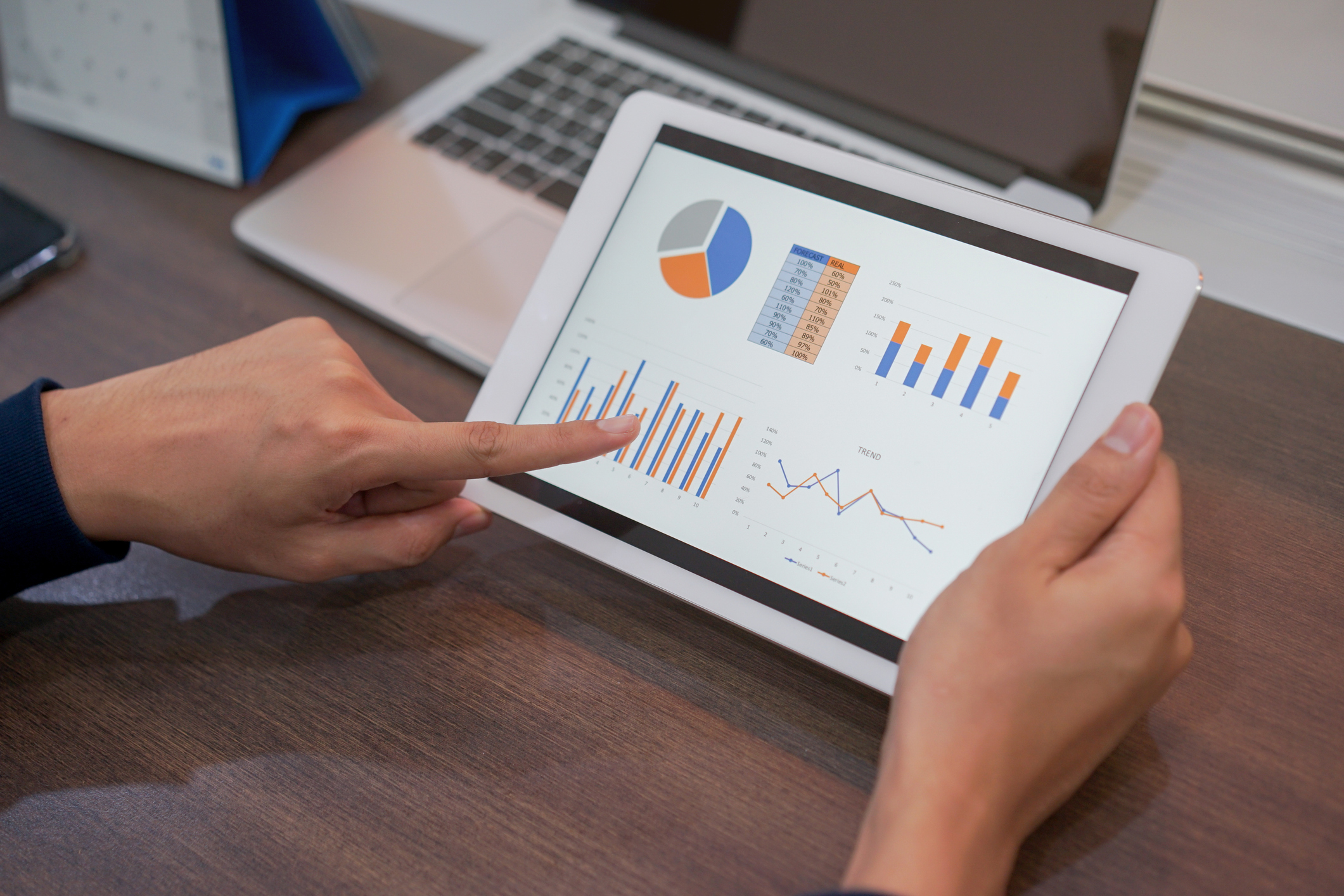 A man's hand pointing to a dashboard on a tablet screen. Credit: https://www.istockphoto.com/portfolio/ChainarongPrasertthai?mediatype=photography