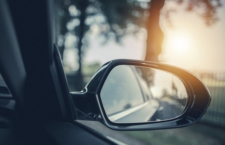 Looking into a car rearview mirror that has a blindspot. Credit: https://www.istockphoto.com/portfolio/welcomia