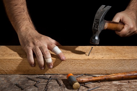 Craftsman badly hammering a bent nail and with bandages on his fingers. Credit: https://www.istockphoto.com/portfolio/Luciano_Queiroz