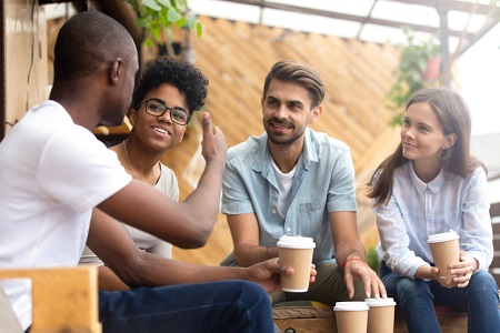A group of people sharing a story over coffee. Credit: https://www.istockphoto.com/portfolio/fizkes