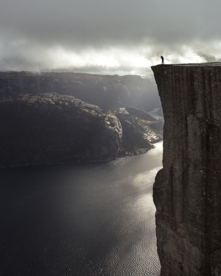 Person standing at a tall cliff face. Credit: Joseph Shelly