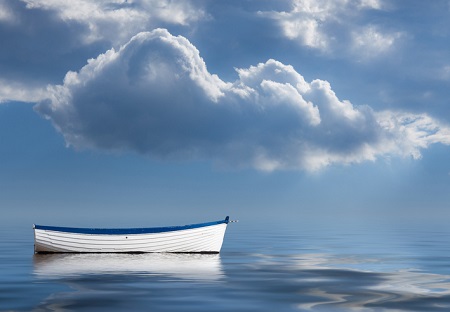 An empty old rowing boat marooned at sea. Credit: https://www.istockphoto.com/au/portfolio/BackyardProduction