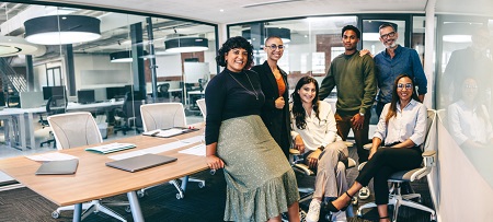 Team of business people smiling ina boardroom. Credit: https://www.istockphoto.com/portfolio/jacoblund