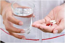 taking some tablets with a glass of water